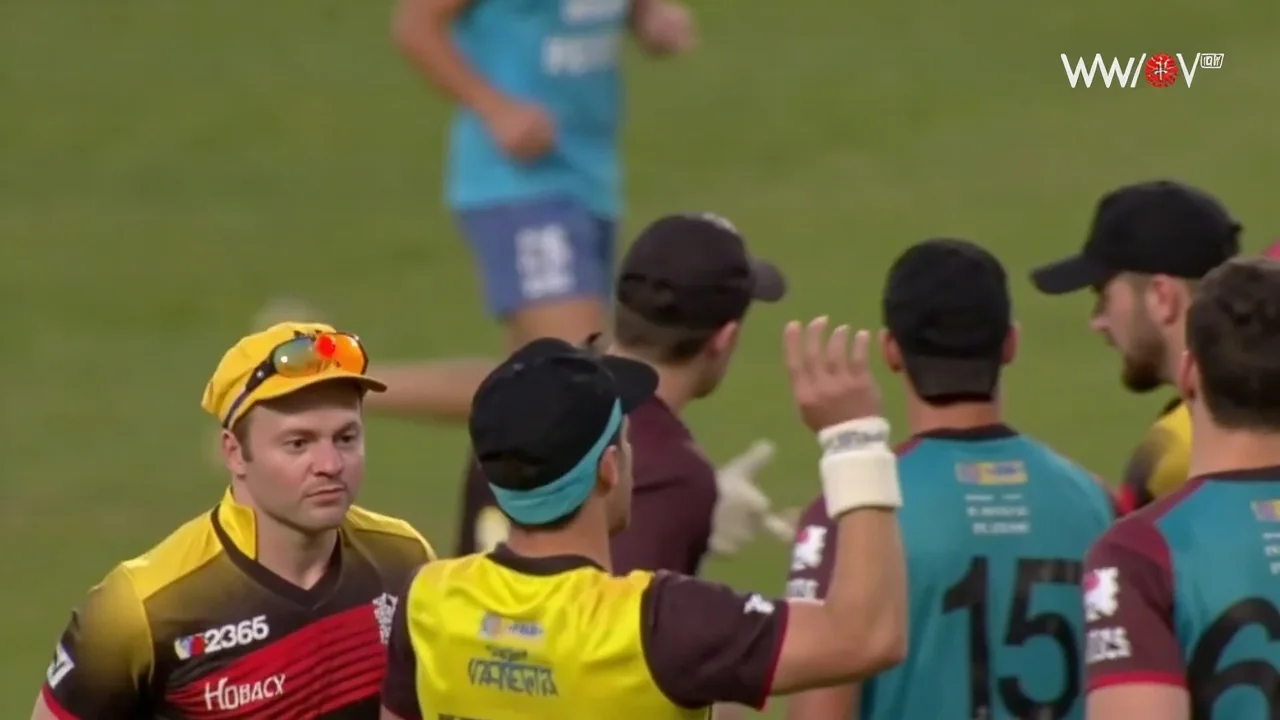 Cricket players setting the field around the pitch during a match
